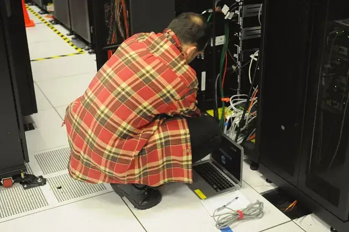 Technician working inside a server rack